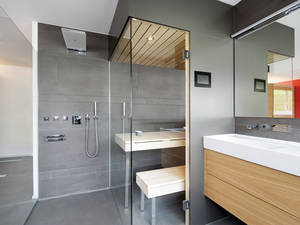 Viel Komfort auf kleinem Raum: Der Saunakubus mit zwei rahmenlosen Glasfronten ist mit Touchscreen-Steuerung, integrierten Lautsprechern und stimmungsvollen Leuchtspots ausgestattet. Küng Wellness.