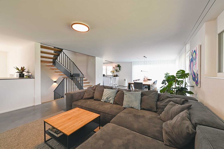 Holz und Metall im Dialog: Die filigrane Treppe wird zur zentralen Achse, die alle Ebenen elegant miteinander verbindet.