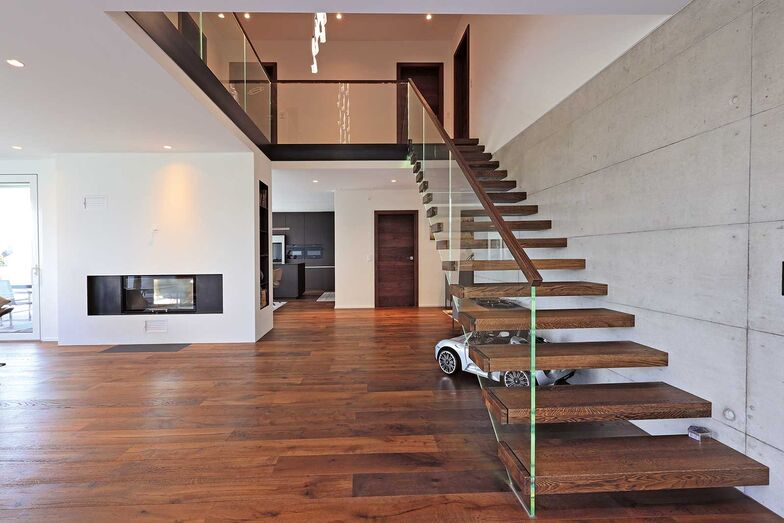 Die frei schwebend wirkende Treppe erhebt sich elegant im grosszügigen Luftraum.