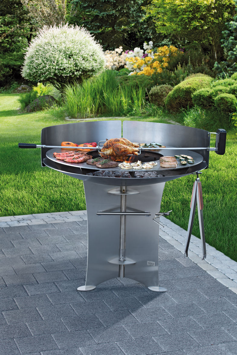 Aufsätze verwandeln die Feuerschale in einen Gourmet-Grill: Mit motorisiertem Grillspiess, Grillplatte und einem Dreizack für Pfannen oder ein Feuerring-Einsatz aus Edelstahl. SIWA AG.