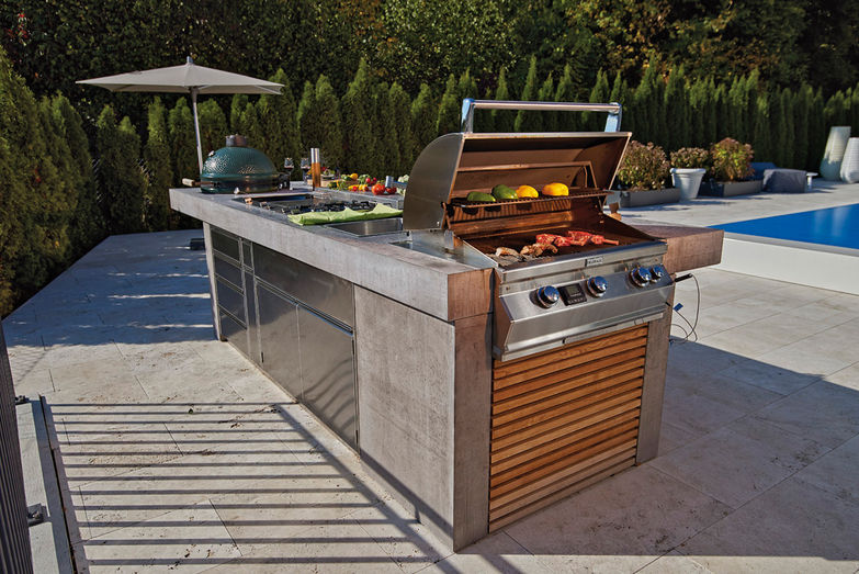 Outdoorküchenexperte Mischa Weber kombiniert Wok und Gas, Holzkohle oder Niedergaren mit Kühlschrank, Herd und Waschbecken und baut alles in eine exklusive Küchenzeile ein. Hans Ball Gartenbau AG.