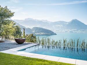 Zusammen mit der gekiesten Ruhezone im Schatten der Bäume und einer Feuerschale entsteht eine perfekte Outdoor-Wellness-Oase, um seine Batterien wieder aufzuladen. Edelstahlpool mit Infinity-Überlauf, LED-Unterwasserbeleuchtung und Jet-Düsen. Zireg Ziswiler GmbH.