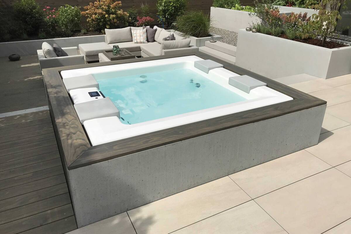 Gut integriert: Hier wurde ein Whirlpool «Strato 2.1» mit drei Sitz-/Liegeplätzen und einer Massageliege elegant in den Loungebereich eines Privatgartens integriert. Er ist aus Sanitäracryl gegossen und rundum isoliert. Für Ganzkörpermassagen stehen zehn Superjets, zwei Turbojets, zehn Microjets und acht Luftsprudeldüsen zur Verfügung. Wetterfestes Holz und Sichtbeton sorgen für ein ansprechendes Gesamtbild. Vivell AG.