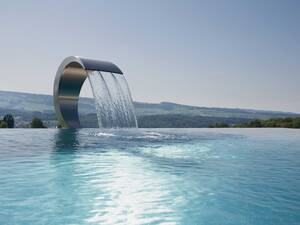 Einfach erfrischend: Eine Schwallbrause ist Blickfang, Massagestation und Frischekick in einem. Diese krönt einen Infinity-Pool aus Edelstahl. Die aussergewöhnliche Anlage mit fast 50 Quadratmetern Wasserfläche wurde von der Vereinigung «Aqua Suisse» zum schönsten privaten Freibad der Schweiz gekürt. Vita Bad AG.