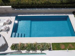 Zum Schwimmen und Relaxen: Zehn Meter langes Schwimmbecken mit Gegenstromanlage, Überlaufrinne und Massagestation. Innenverkleidung Bisazza-Glasmosaik, Umrandung Travertin-Natursteinplatten. Die Schwimmbadsteuerung reguliert Wasseraufbereitung, Heizung, Gegenstromanlage, Abdeckung und Beleuchtung. AC Schwimmbadtechnik AG.