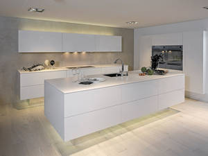 Der Sockel aus Spiegelglas ist ein stilbildendes Element dieses zeitlosen Küchenmodells aus Schongau. Furrer Küchen.