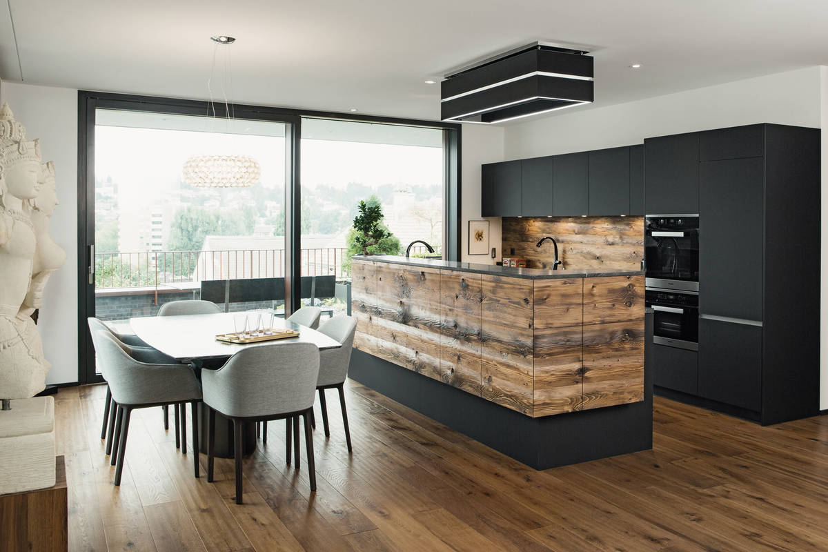 Das auf den Parkettboden abgestimmte Altholz verleiht der Inselküche eine beeindruckende Natürlichkeit. Elbau.