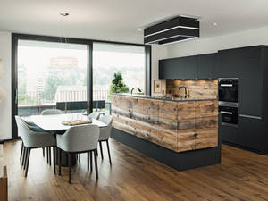 Das auf den Parkettboden abgestimmte Altholz verleiht der Inselküche eine beeindruckende Natürlichkeit. Elbau.