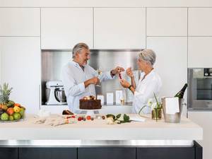  Viel Platz bietet die grossflächige Küchenschrank-Kombination, die sich dank grifflosem Design und schlichter weisser Lackierung subtil in den Raum fügt. Herzog Küchen AG.