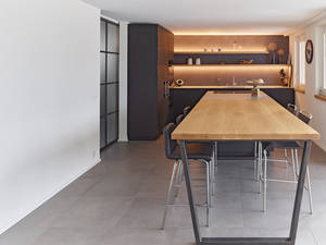 Eichenholz, gespachelte Rückwände, Metallelemente und Edelstahlabdeckungen – so geht die moderne Küche mit gemütlichem Charakter. Oesch Innenausbau.