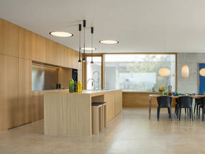 Das helle Eichenholz schenkt der Küche ein warmes Ambiente. Die grosszügige Nische mit Edelstahlrückwand wirkt modern und zeitlos. Elbau.