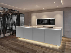 Die Arbeitsplatte aus weissem Quarzstein scheint durch die Konstruktion des Lichtbandes zu schweben. Selbiger Effekt wird bei den Geräten in der Rückwandzeile eingesetzt. Furrer.