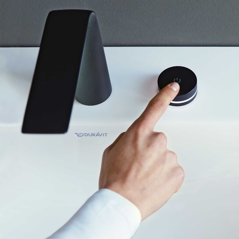 Einfach und intuitiv wird der Bedienknopf mit integriertem LED-Farbring betätigt. Durch leichtes Antippen der Elektronikarmatur «D.1» startet und stoppt der Wasserfluss, durch Drehen verändert sich die Wassertemperatur. Duravit.