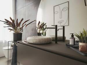 In diesem Badezimmer zieht ein echtes Schmuckstück die Blicke auf sich: Ein rundes Aufsatzbecken aus Carrara-Marmor, das mehr als nur ein funktionales Objekt ist – es ist ein Kunstwerk. Dazu passt mit seiner klaren Linienführung das Unterbaumöbel  "Piana" in Basalto mit einer Abdeckung aus Flumood, das praktischen Stauraum bietet. Die Waschtischarmatur «Via Tortona» von Gessi in mattem Schwarz setzt einen modernen Akzent. Hans Eisenring.