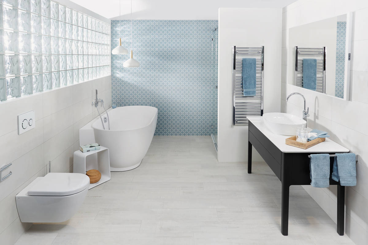 Wandkacheln im mediterranen Stil und verchromte Armaturen geben dem hellen Badezimmer eine natürlich schlichte Atmosphäre. Sabag.