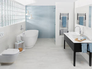 Wandkacheln im mediterranen Stil und verchromte Armaturen geben dem hellen Badezimmer eine natürlich schlichte Atmosphäre. Sabag.