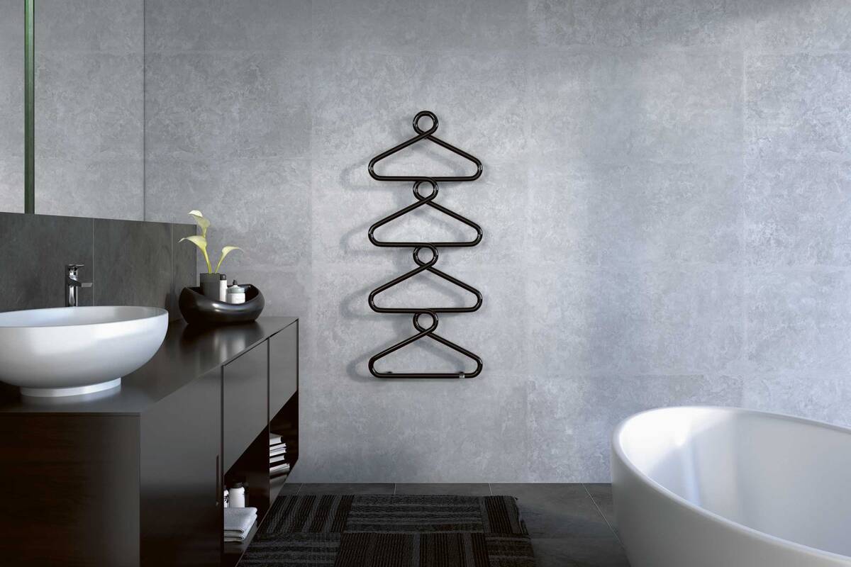 Aussergewöhnliche Inszenierung des Badheizkörpers: Eine schwarze Gliederkette in der Anmutung von Kleiderbügeln ermöglicht das bequeme Aufhängen und Wärmen von Handtüchern und Badtextilien. Zehnder Group Schweiz AG.