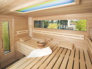 Von innen und aussen ein schöner Anblick: Auf die Terrasse abgestimmte Gartensauna von  Fitness-Partner AG.