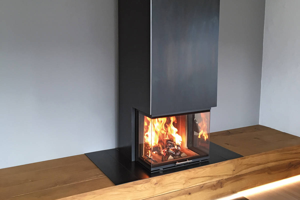 Schlicht schön: Diese Massanfertigung verbindet das Warmluftfeuermöbel aus Zunderstahl mit TV-Möbel und Schubladen. Baumann.