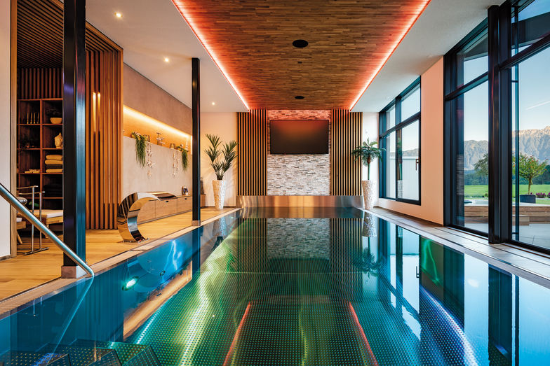 Schwimmbad mit Gegenstromanlage, grossem TV-Bildschirm und direktem Zugang zum Garten.