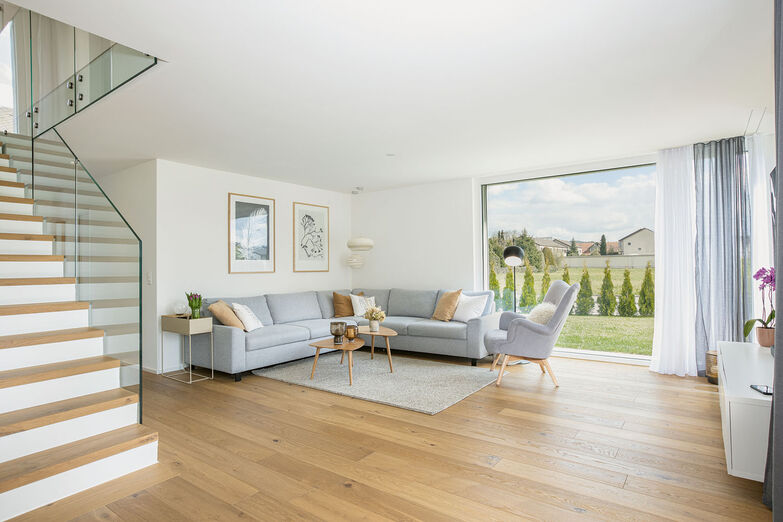 Grosse Fenster schaffen Weite und holen die Natur ins Haus.