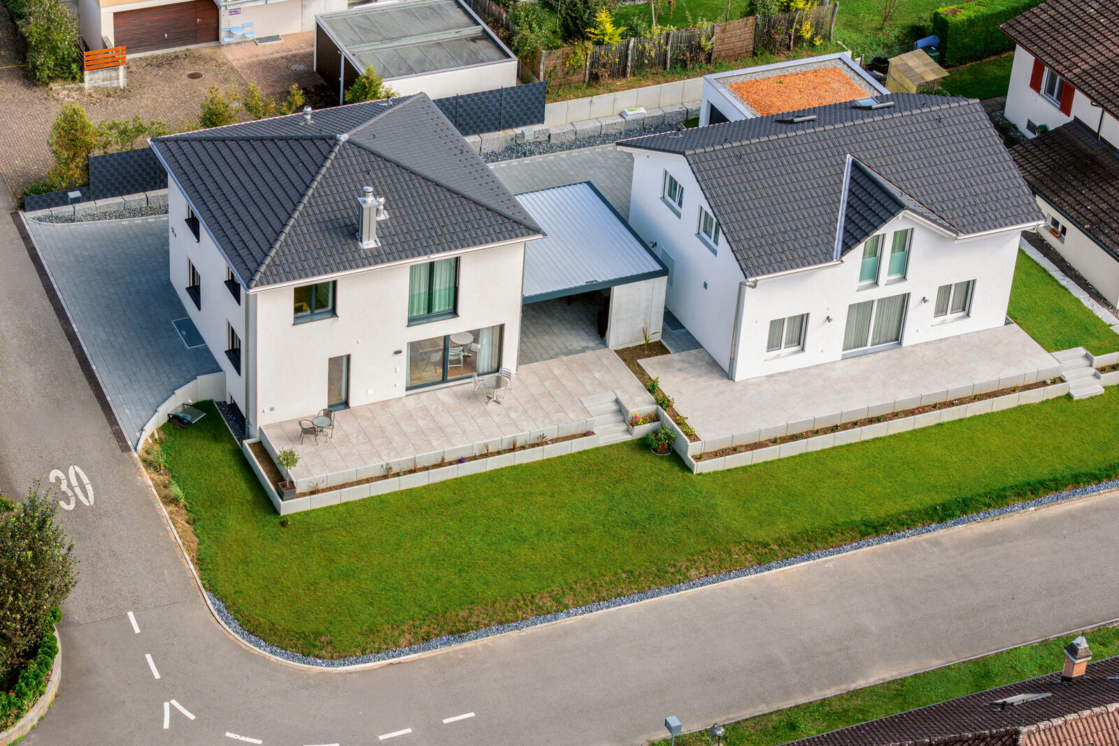 Die leichte Hanglage wird geschickt ausgeglichen, so dass sich das Haus perfekt in das Eckgrundstück einfügt.