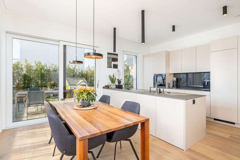 Küche samt Essplatz und die zugeordnete Terrasse bieten Platz für Mahlzeiten in geselliger Runde.