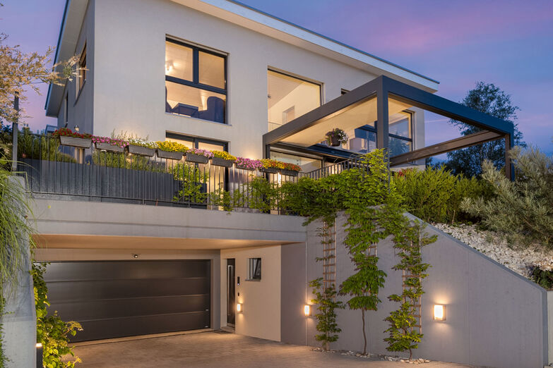 Der Hauseingang liegt geschützt unter dem Vordach der Garage.