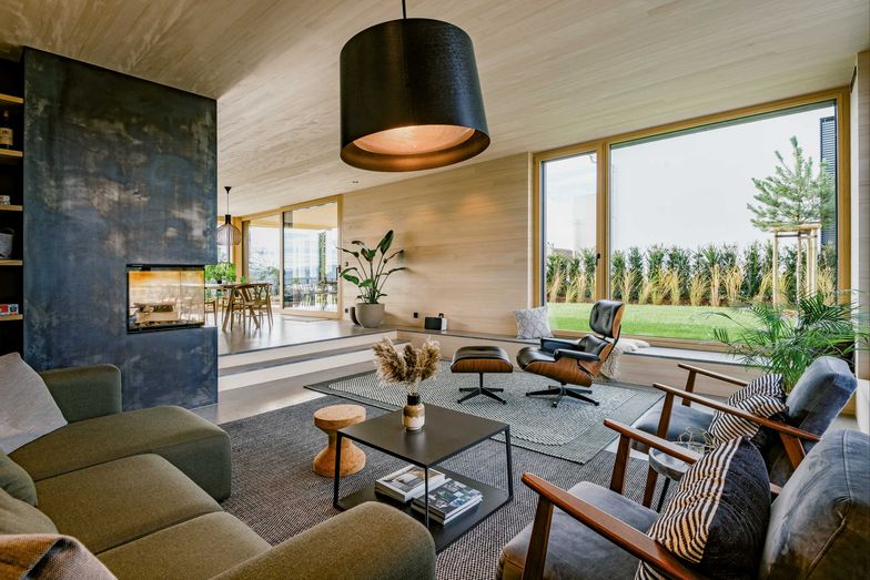 Der Wohnraum mit dem Cheminée hebt sich durch das versetzte Niveau von Küche und Essraum ab.