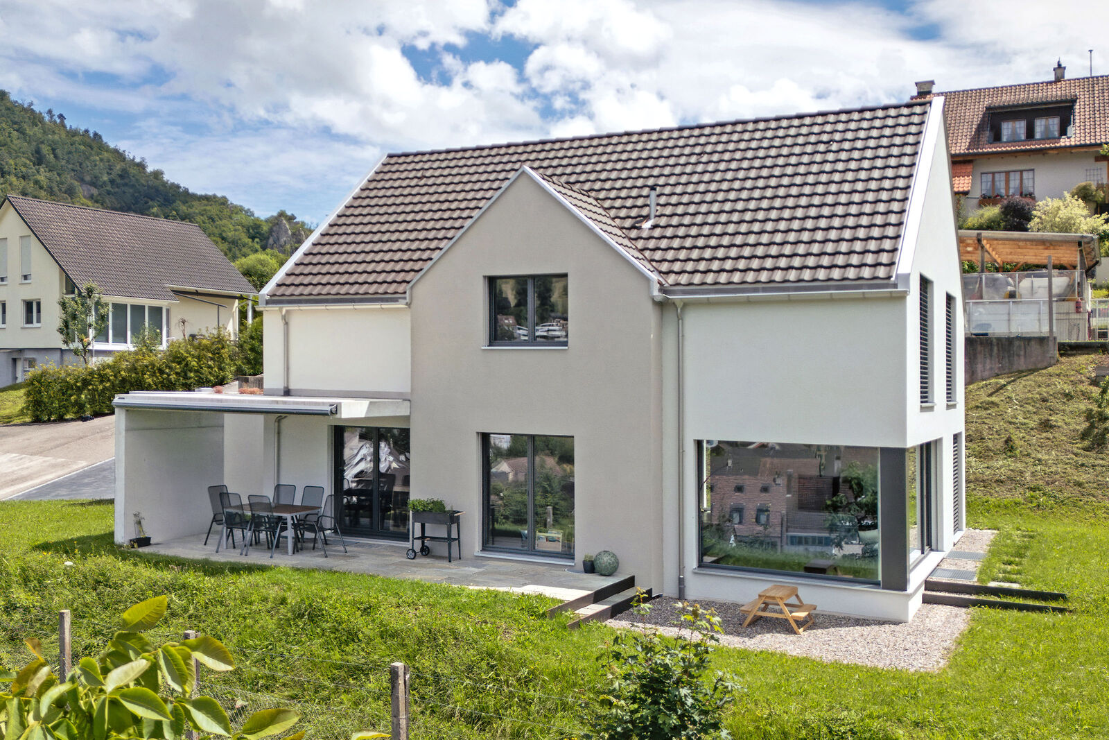 Das Einfamilienhaus überzeugt mit klaren Linien, ­kontrastreicher Fassadengestaltung sowie einem ­Satteldach und fügt sich ­stimmig in die Umgebung ein.