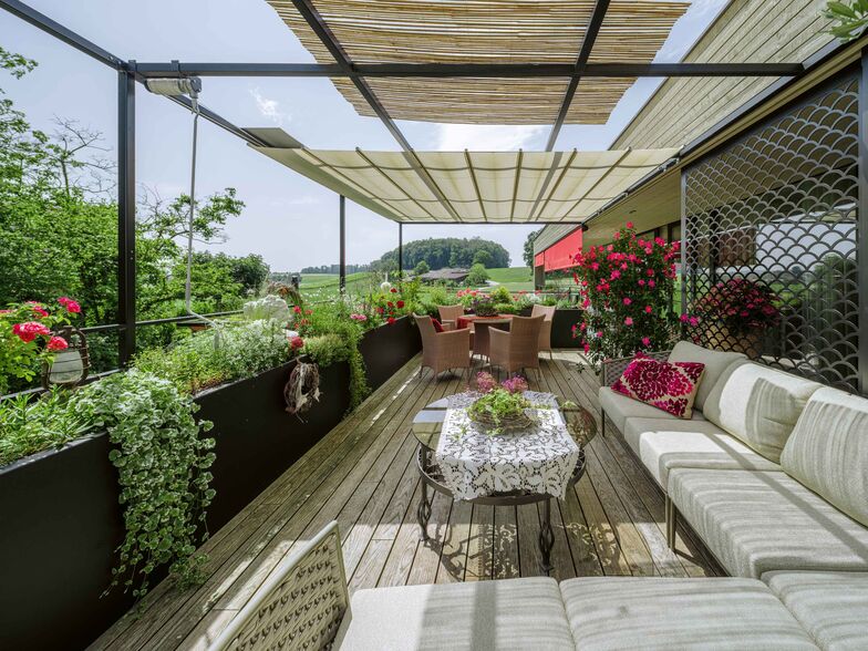 Die Terrasse erstreckt sich über die Südseite vor dem Bad-, Schlaf- und Wohn-/Essbereich.