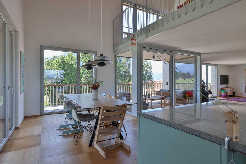 Der Küchenbereich mit der Galerie ist offen und grosszügig gestaltet. Das Geländer aus den zierlichen, grauen Stahlstangen dient der Sicherheit und wirkt dennoch luftig und filigran.