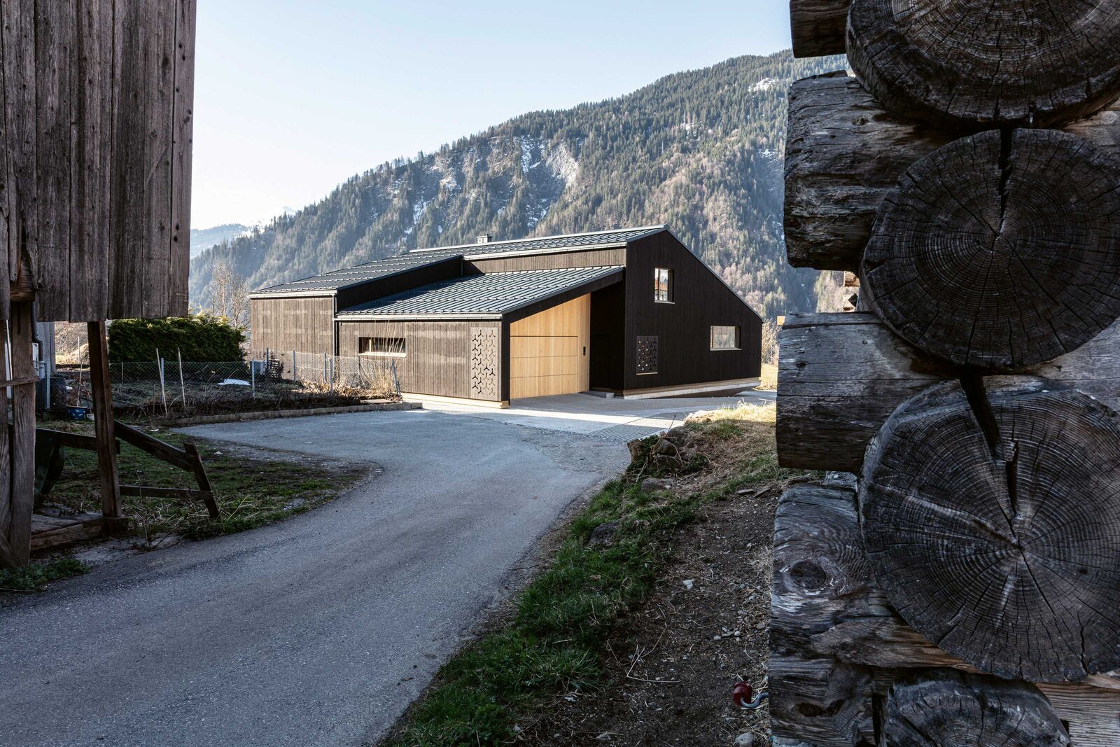 Die Fichtenschalung des Holzbaus ist in einer dunklen Schlammfarbe gestrichen.