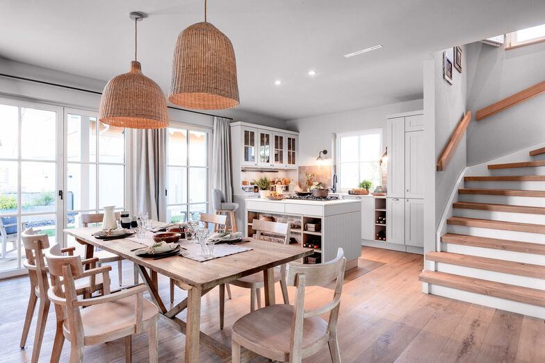 Auch am Essplatz und in der Küche prägt Holz das Ambiente. Die Treppe rechts führt die Treppe ins Obergeschoss.