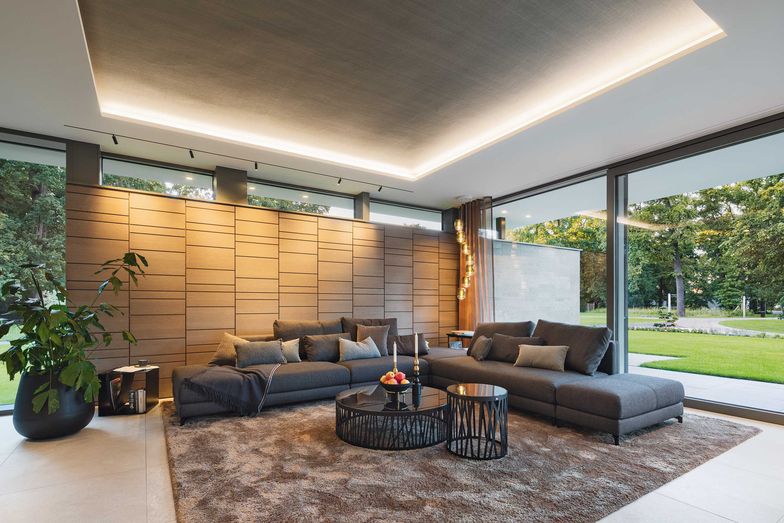 Schwellenlose Schiebetüren ziehen den grünen Garten und das Tageslicht tief in das Haus.