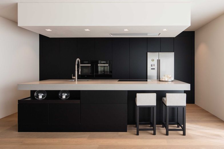 Die abgehängte Decke mit den Einbauleuchten über dem Küchenblock verbirgt den Dunstabzug.