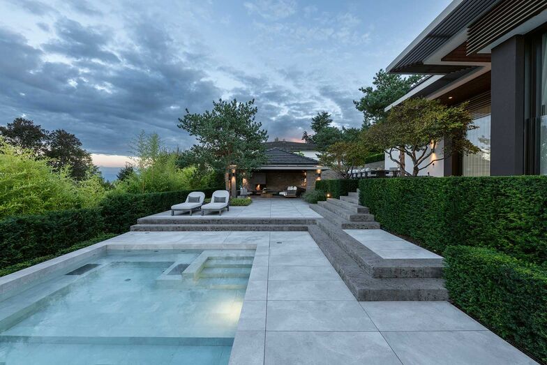 An den Pool schliesst sich die Sonnenterrasse an, dahinter liegt das Poolhaus mit der Lounge.