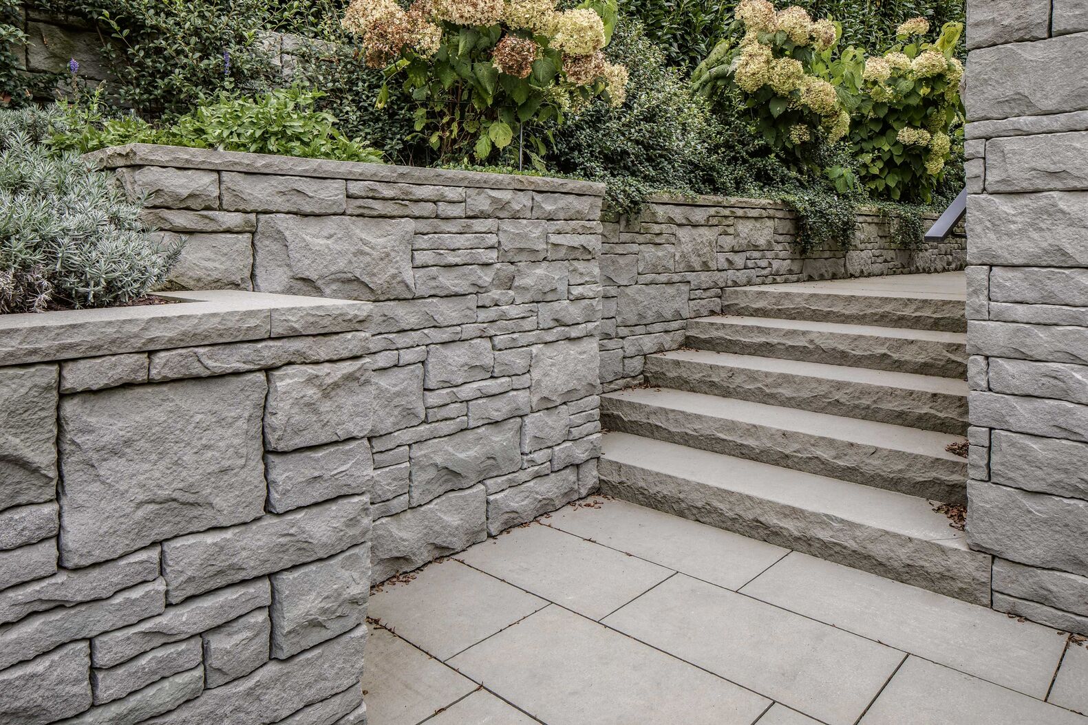 Dank der neutralen Farbgebung fügt sich der Bollinger Sandstein gut im Aussenbereich ein. Er ist für Böden, Mauern, Blockstufen oder Fenstereinfassungen einsetzbar. Müller Naturstein AG, www.mueller-naturstein.ch