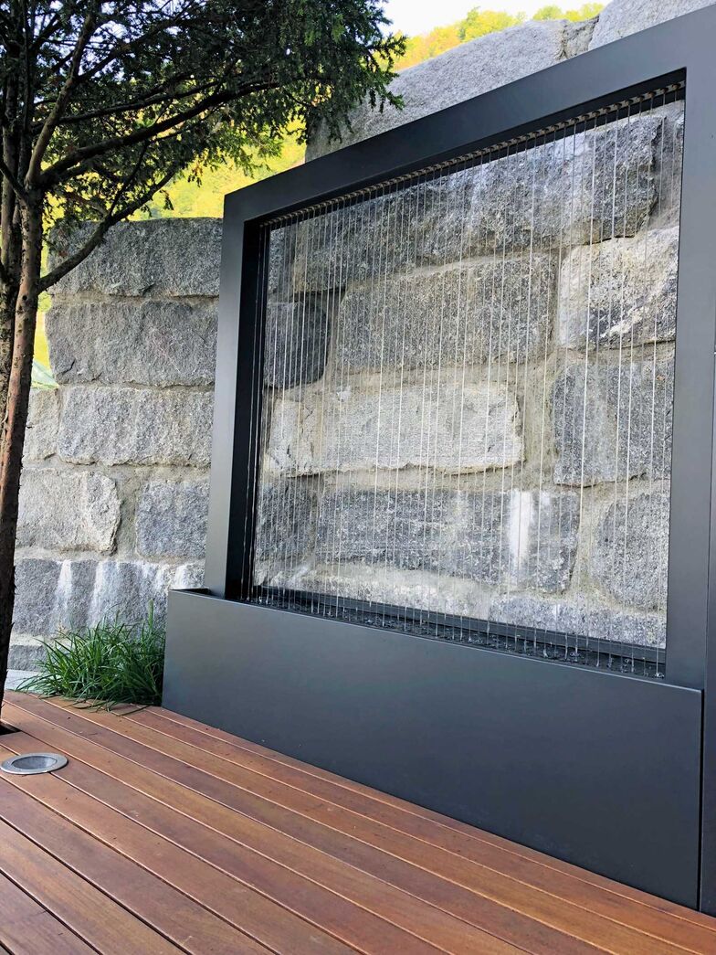 Dieser Aluminiumbrunnen ist ausgestattet mit Chromstahlseilen und zaubert einen wunderbaren Wasservorhang ohne Geräusche. Im Sommer kühlt das Wasser die Umgebung. Mein Topf GmbH, www.meintopf.ch