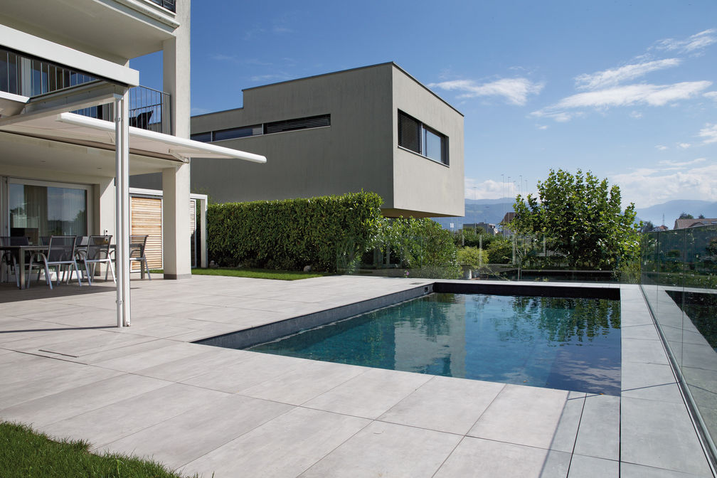 Der «Vitapool Classic» im Format 6,5 x 3,35 m wurde exakt an die umgebenden Platten angepasst, damit diese nicht geschnitten werden mussten und das Fugenbild gleichmässig bleibt. Wegen der Hanglage entschied man sich für eine Stahl-Holz-Konstruktion in Leichtbauweise. Vita Bad AG.