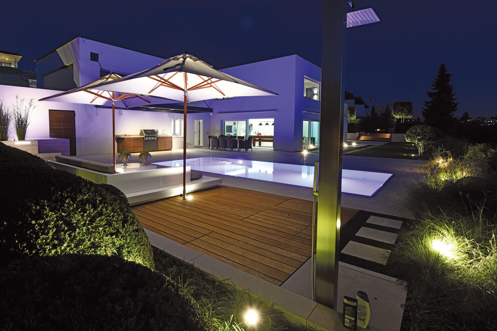Pool- und Wellnessanlage mit Aussenküche, geplant von der Hufschmid Gartenbau AG in Zusammenarbeit mit der Staub Designlight AG.
