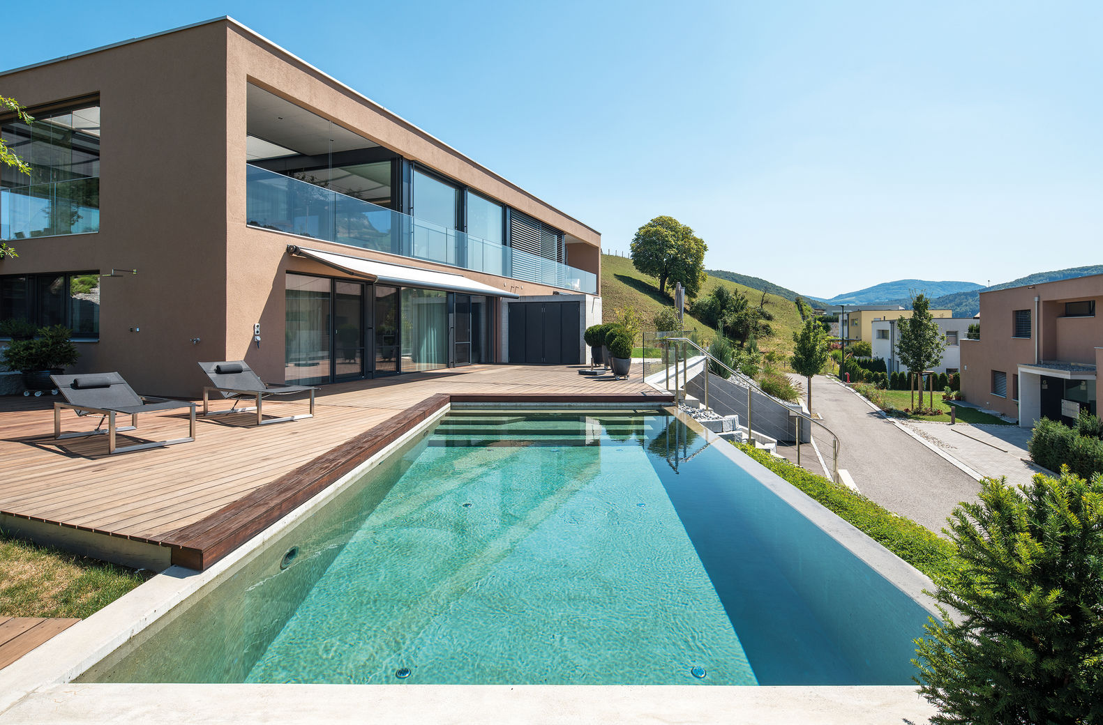 Die Anlage gehörte von Anfang an zur Planung des Hauses, die Gestaltung wurde perfekt auf die Architektur abgestimmt. Becken in Sichtbeton, Umrandung teils Holz, teils Beton. Vivell AG.
