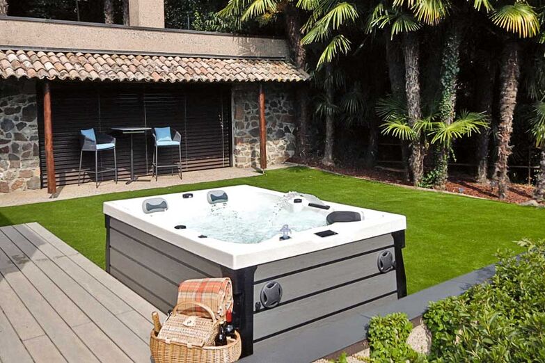 Rückzugsort im Grünen: Ein hochwertiger Whirlpool fügt sich harmonisch in die Gartengestaltung ein und wird zum Mittelpunkt für entspannte Abende.
