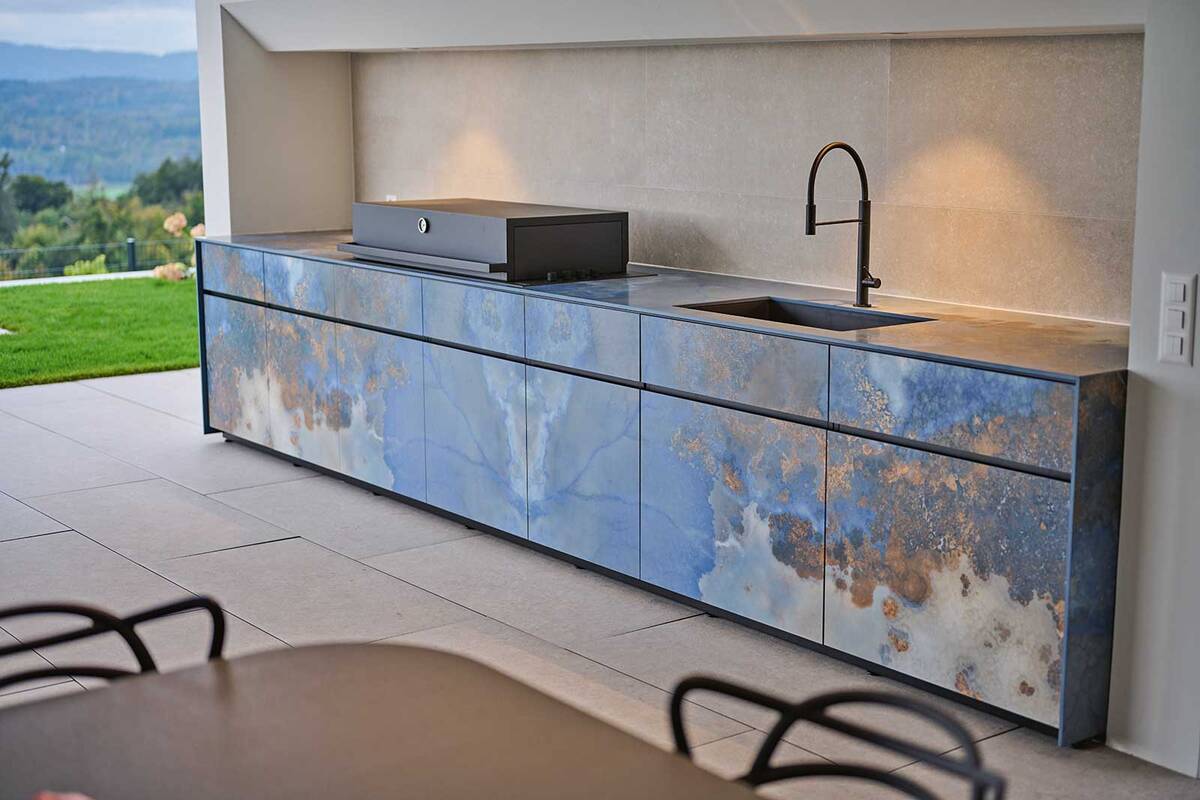 Die «Avers Outdoorküche» von Theiss verspricht gemütliche Grillstunden: «Bookmatch»-Keramikplatten, ein pulverbeschichteter Edelstahlkorpus sowie eine LED-Beleuchtung unter der Arbeitsfläche sind Hingucker dieser wetterbeständigen Outdoorküche. Theiss by Lynx Group GmbH.