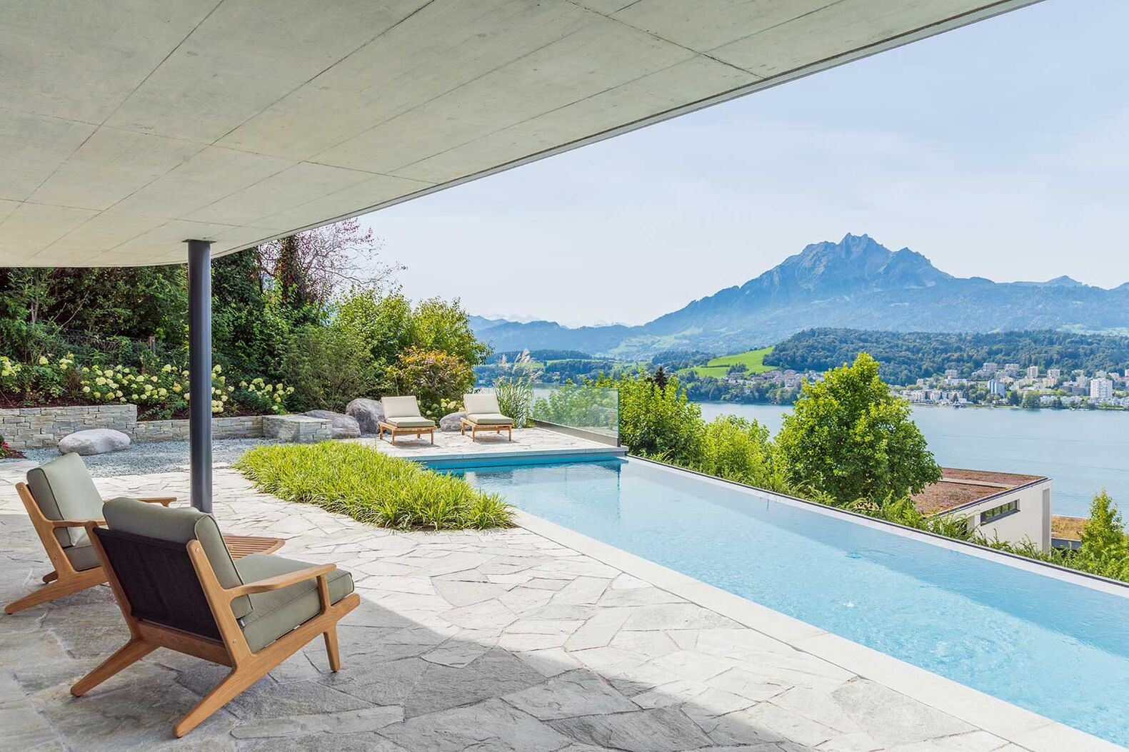 Majestätische Aussicht über den Vierwaldstätter See und auf den Pilatus: Im Beton-Pool lässt sich entspannt floaten oder Bahn um Bahn ziehen mit wechselnden Lichtstimmungen. Nachts zaubert ein LED-Lichtbad zusammen mit einer Unterwasserbeleuchtung magische Momente. Zireg Zisweiler GmbH, www.zireg.ch 