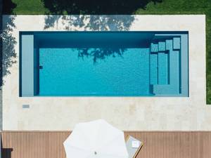 Perfekt integriert: Die mediterrane Wohlfühloase wurde in enger Zusammenarbeit mit dem Gärtner gestaltet. Das Fertigbecken der Marke Riviera Pool mit stirnseitiger Treppe und Flachwasserbereich zum Sitzen und Liegen im Wasser ist mit automatischem PVC-Rollladen und einer vollautomatischen Wasseraufbereitung ausgestattet. Marlin AG.