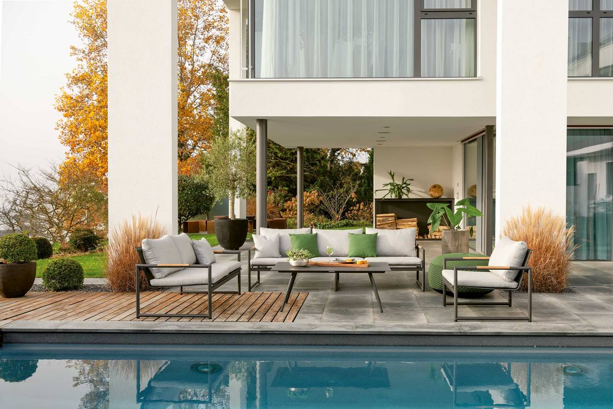 Draussen wohnen: Die wetterfeste Loungegruppe «Antwerpen» ist die sommerliche Alternative zur Couch drinnen im Haus. Das Gestell ist aus pulverbeschichtetem Edelstahl, die Armlehnen aus Teakholz. Hunn Gartenmöbel AG.