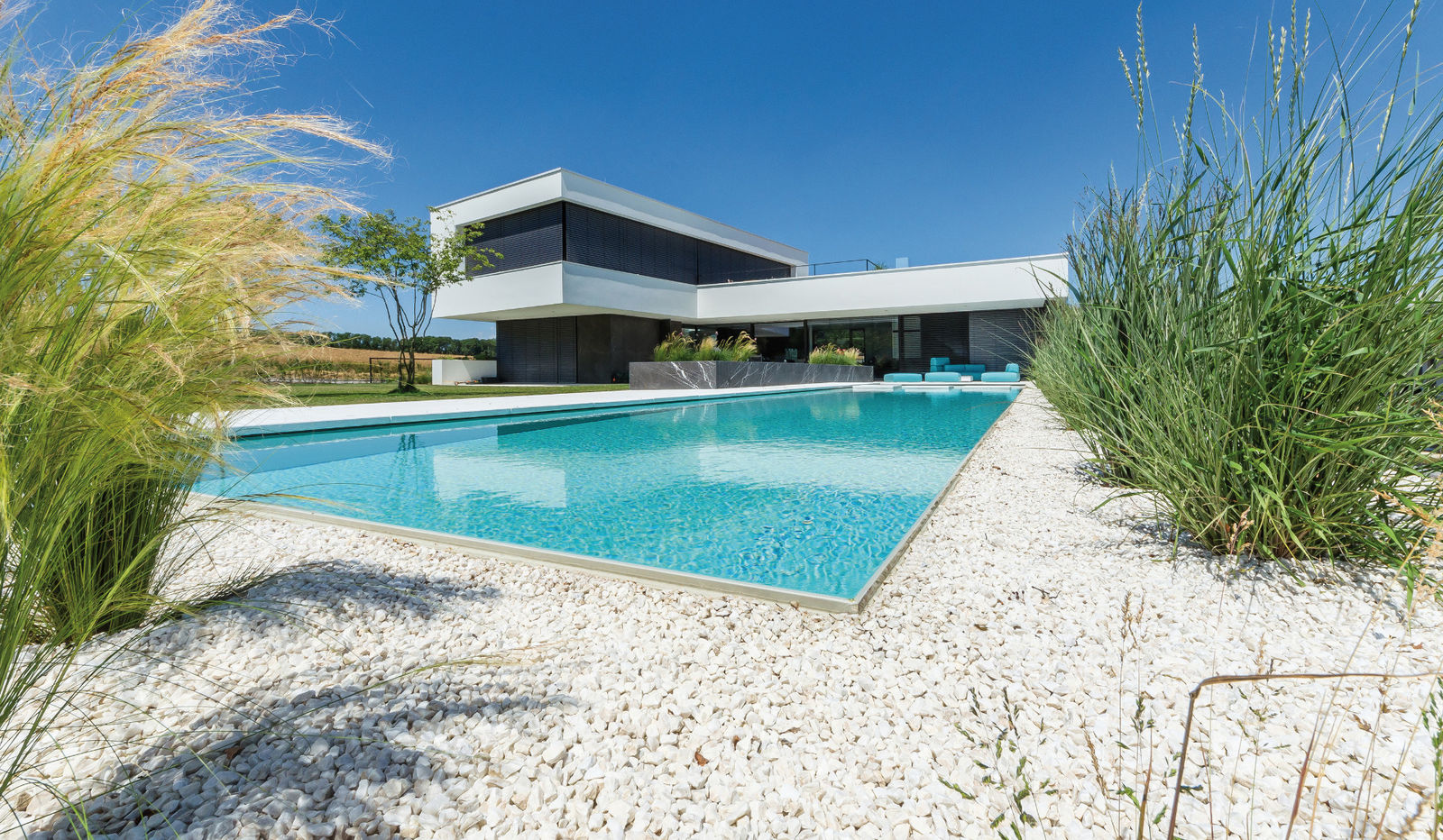 Hier passen sogar die Loungemöbel zur Farbe des Wassers. Das Fertigbecken mit scheinbar schwebenden Betonplatten im Flachwasserbereich gewann 2017 den begehrten Wettbewerb um den Design-Froschkönig, ausgeschrieben von der Biotop Landschaftsgestaltung GmbH.