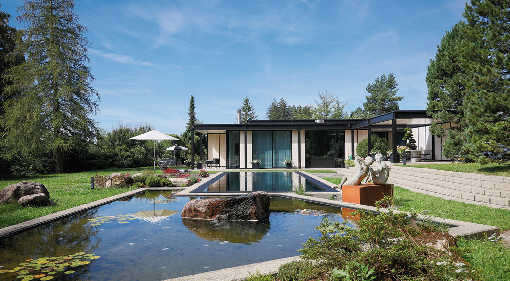 Auch das an den Swimmingpool angrenzende asymmetrische Wasserbecken aus Beton wurde renoviert und neu mit einer schwarzen Folie ausgekleidet. Der Findling musste ausgebaut und nach der Fertigstellung wieder in die Wasserlandschaft gesetzt werden.