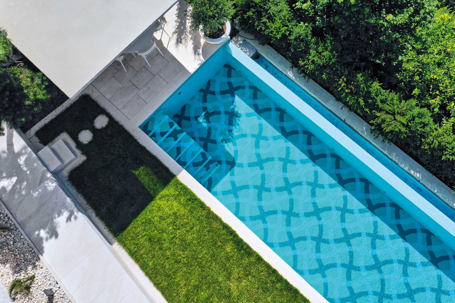 Marlin: Ein elegantes Schwimmbecken in Massivbauweise in der Grösse 11,0 x 2.80 m mit einseitiger Überflutung in ein offenes Ausgleichsbecken. Das Muster für die Mosaik-Auskleidung hat der Architekt Franco Pinazza eigens für diese Anlage entworfen. Eine integrierte Treppe führt ins warme Wasser. Die automatische Rollladen-Abdeckung ist elegant in einem Rucksackschacht verstaut. Drei LED-Leuchten beleuchten das Becken in warmweiss aus, und eine zweistrahlige Gegenstromanlage für sportliches Schwimmen ergänzt den Badespass. Die moderne automatische Schwimmbadtechnik ist mit einer hochwertigen Wasseraufbereitung eingerichtet und garantiert eine optimale Wasserqualität. Das Poolhaus rundet die Gartenbad-Anlage mit Nasszelle perfekt ab. www.marlin.ch